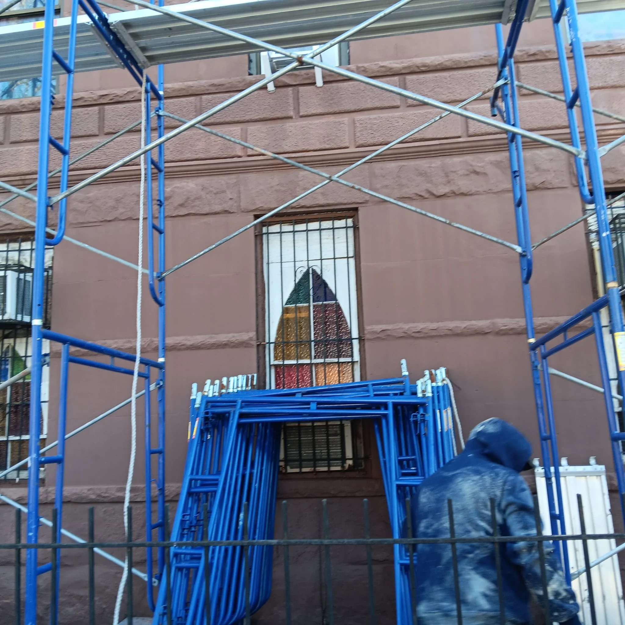 Scaffolding installation with worker assembling frame on building site in Queens NY