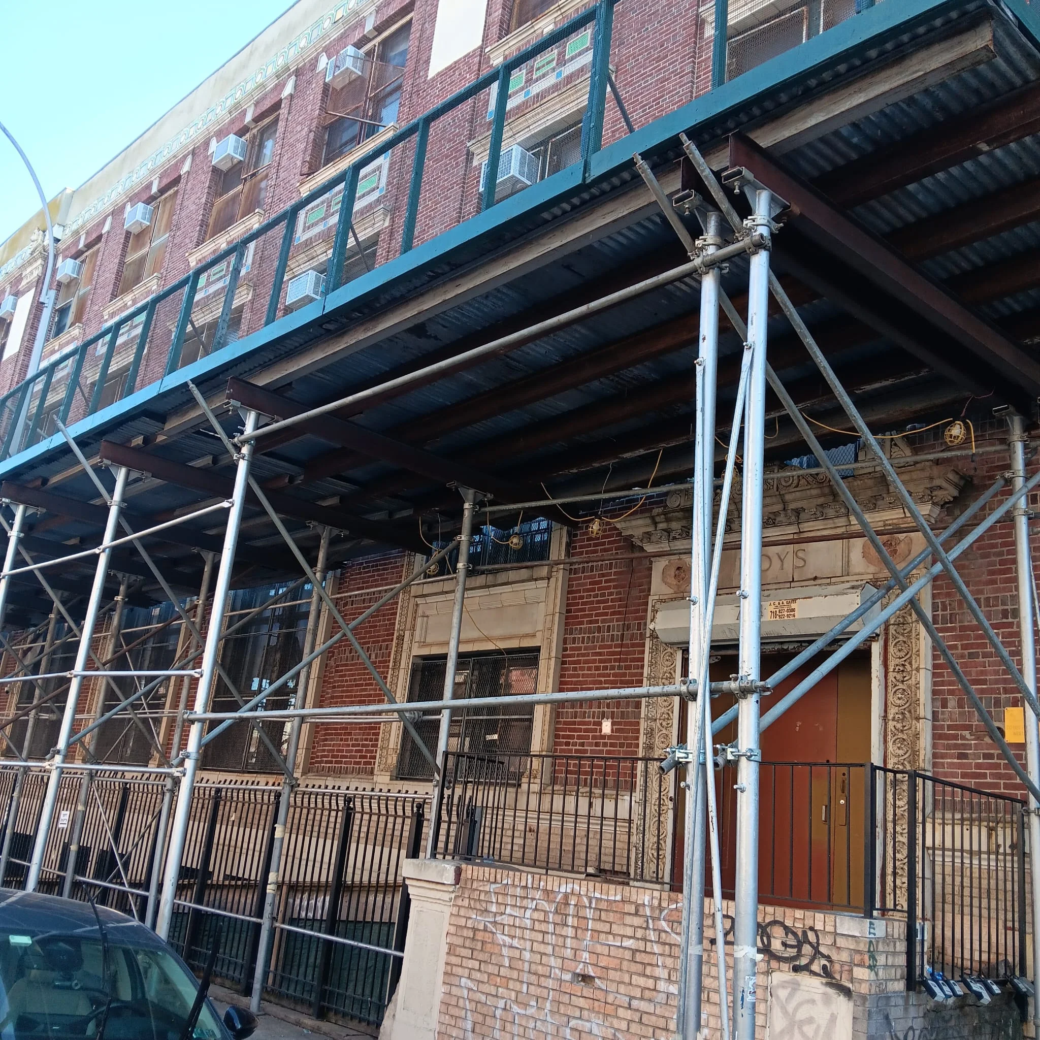 Sidewalk shed scaffolding installed along a building in Queens, NY, offering safety for pedestrians and secure access during ongoing construction.
