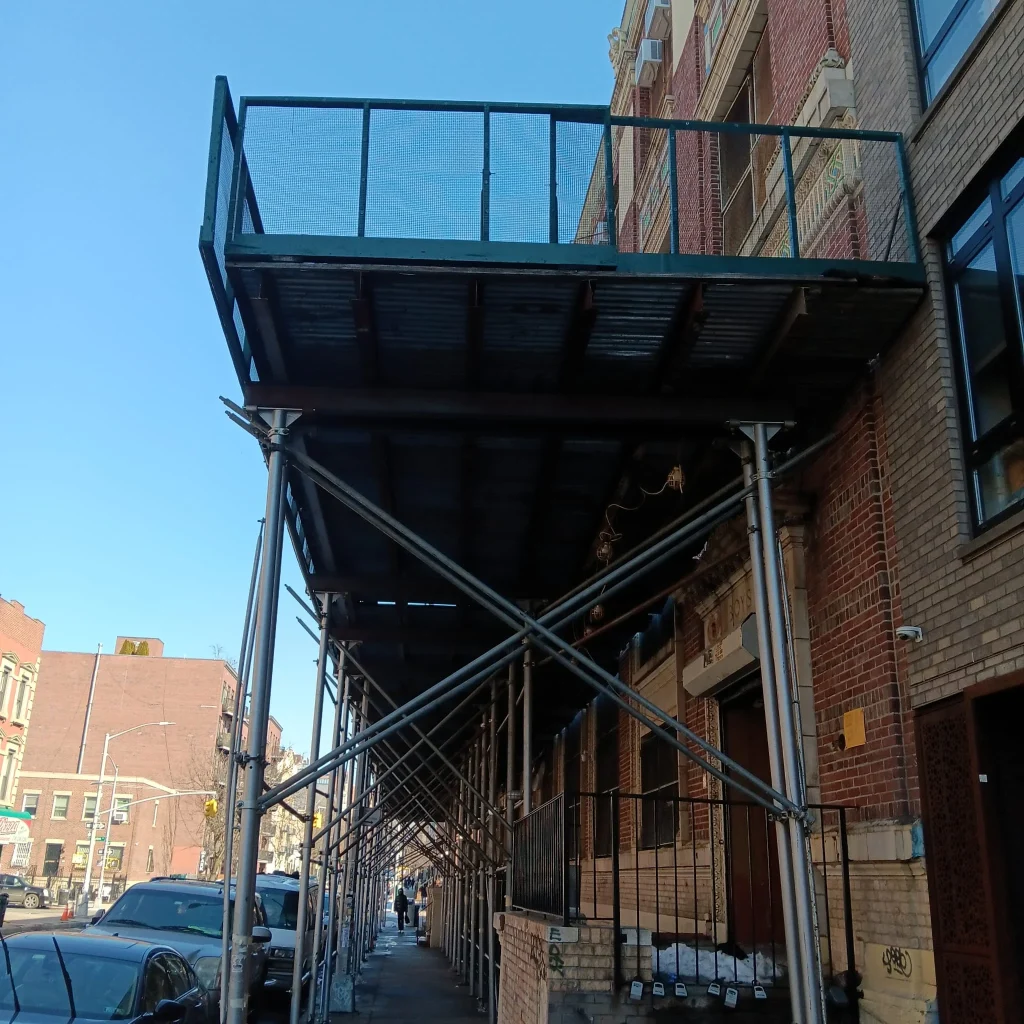 Sidewalk shed and scaffolding structure installed for building work in Queens New York