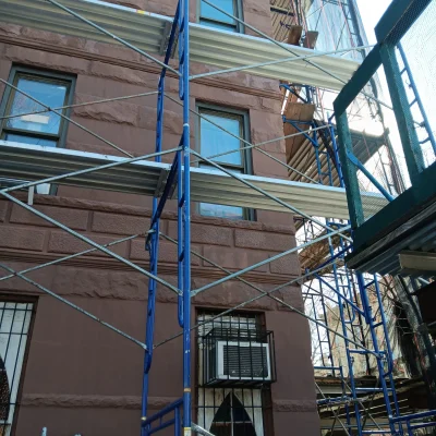 Pipe scaffolding setup on a street in Queens, ensuring safety for pedestrians during building work