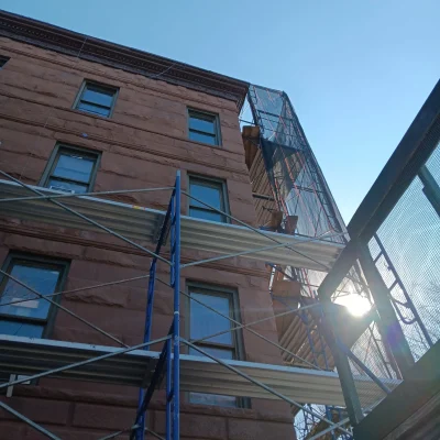 Scaffolding installation on brick building in Queens NY with metal frame structure