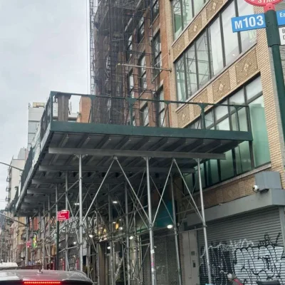 Scaffolding and sidewalk shed installed on a building in Queens, NY, with clear pricing and no hidden costs, ensuring trust and transparency for clients.