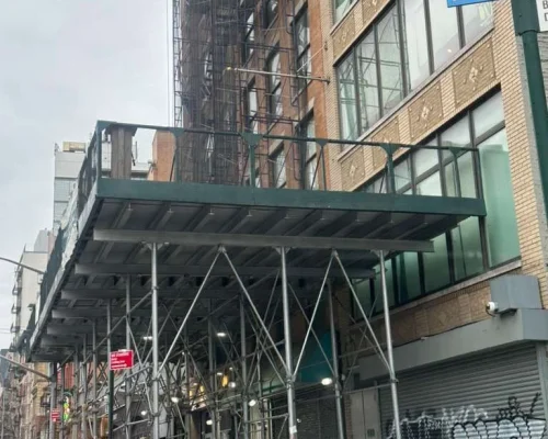 Scaffolding and sidewalk shed installed on a building in Queens, NY, with clear pricing and no hidden costs, ensuring trust and transparency for clients.